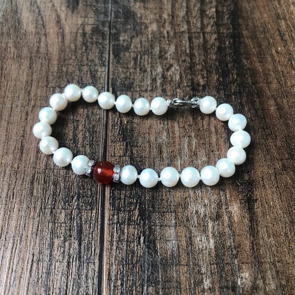 Pearl bracelet with red bead